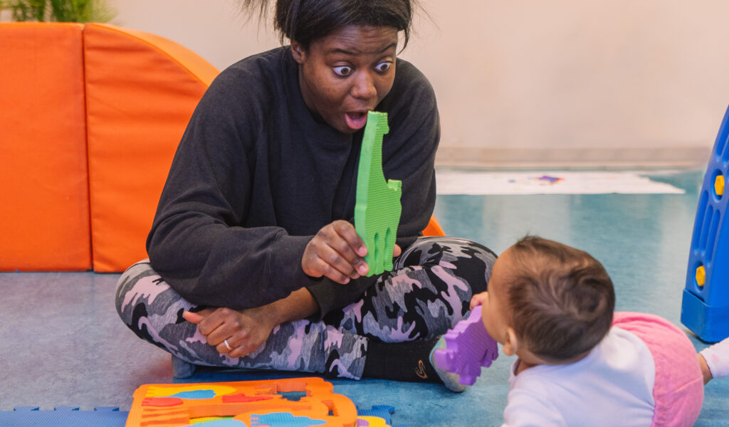 Une maman interagit avec son bébé à l'aide d'un puzzle d'animaux, favorisant le jeu, l'éveil et les interactions parent-enfant.