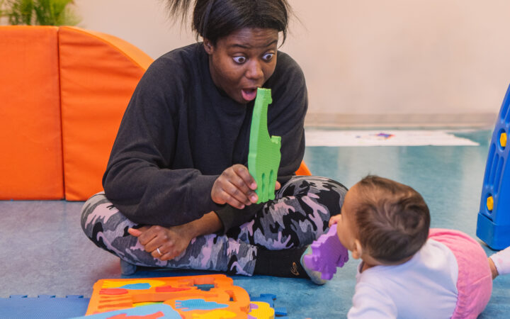 Une maman interagit avec son bébé à l'aide d'un puzzle d'animaux, favorisant le jeu, l'éveil et les interactions parent-enfant.