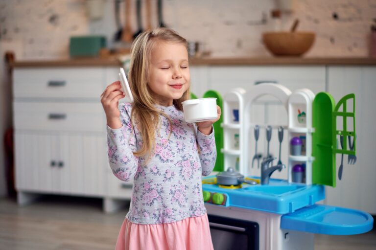 Enfant préparant une recette imaginaire dans une cuisine miniature lors d'une activité de jeu symbolique.